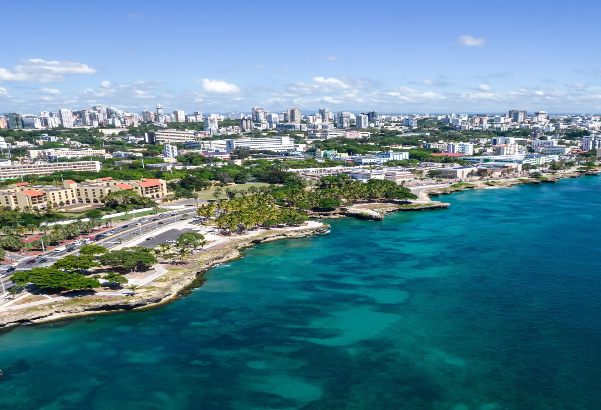 A view of Santo Domingo's coast with modern buildings overlooking a blue sea.