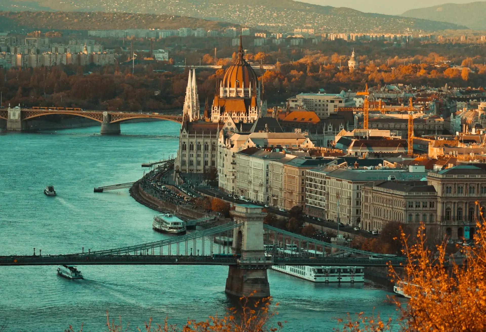 A view of Budapest’s Parliament building on the banks of the Danube River with a backdrop of historic architecture.