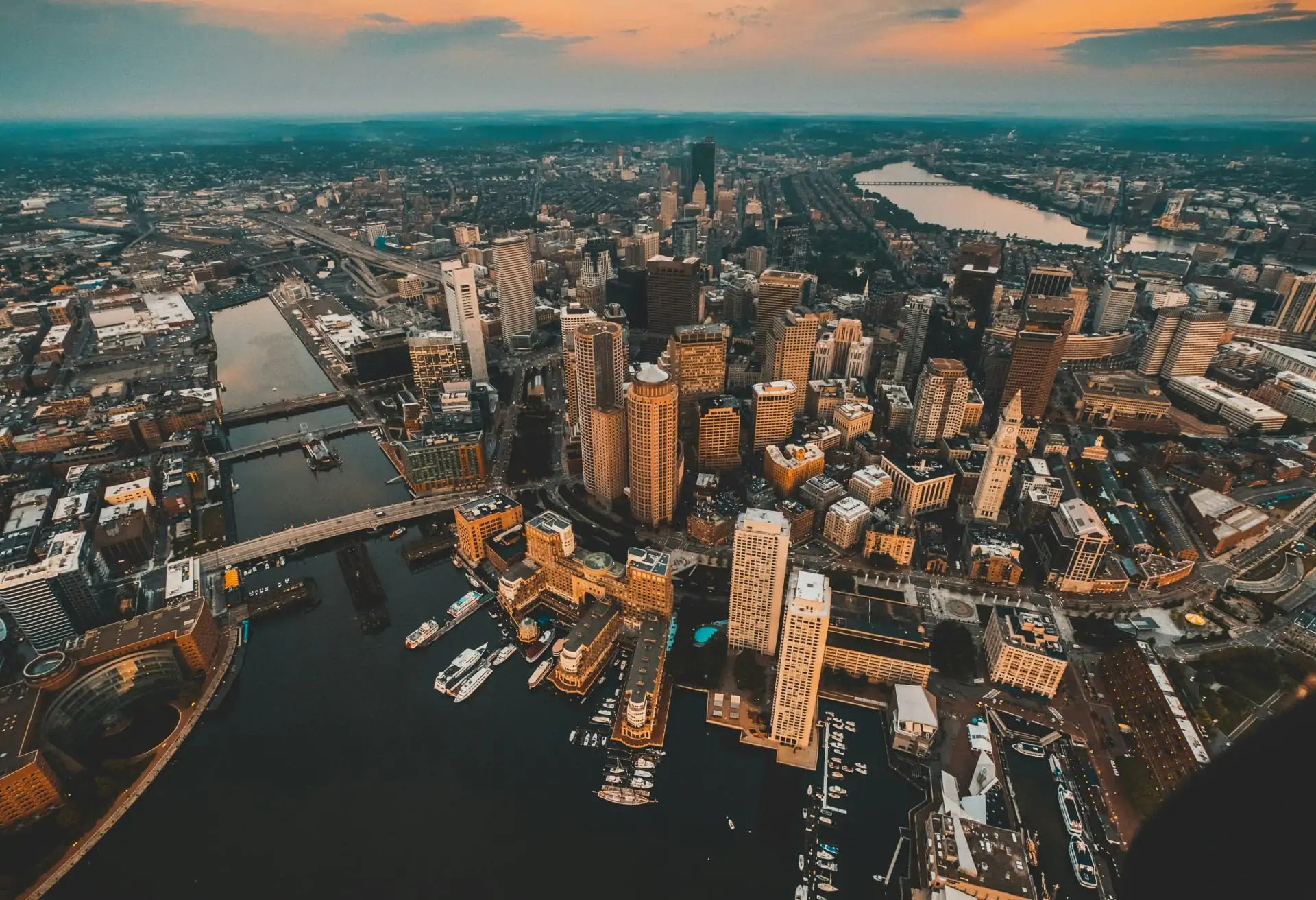 An aerial view of Boston’s skyline with the harbor and a blend of old and new architecture.