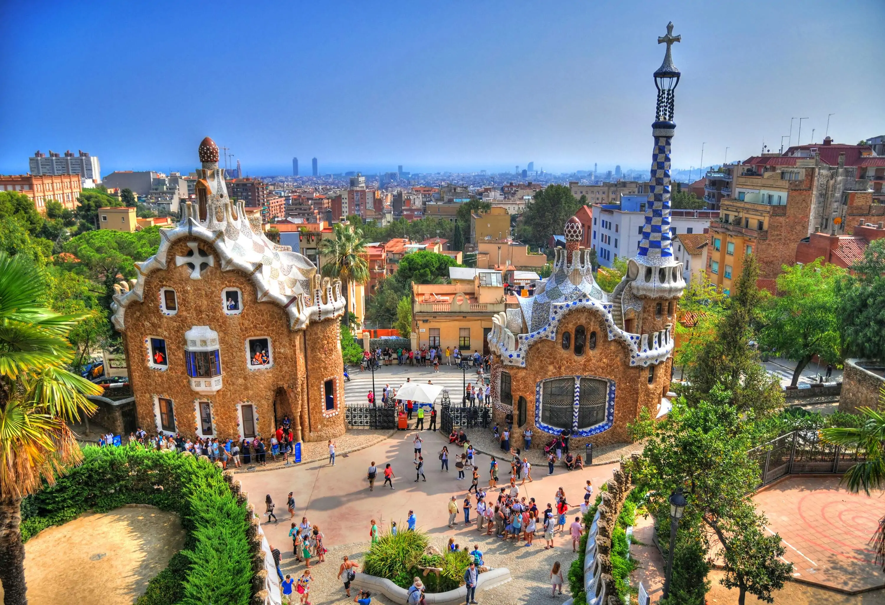 Aerial view of people inside an amusement park with two gingerbread buildings by the entrance.